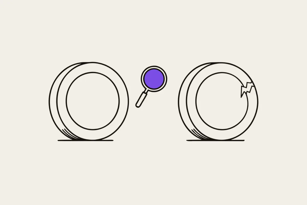 Illustration, both sides of a coin, one gleaming, the other cracked, a small magnifying glass between them